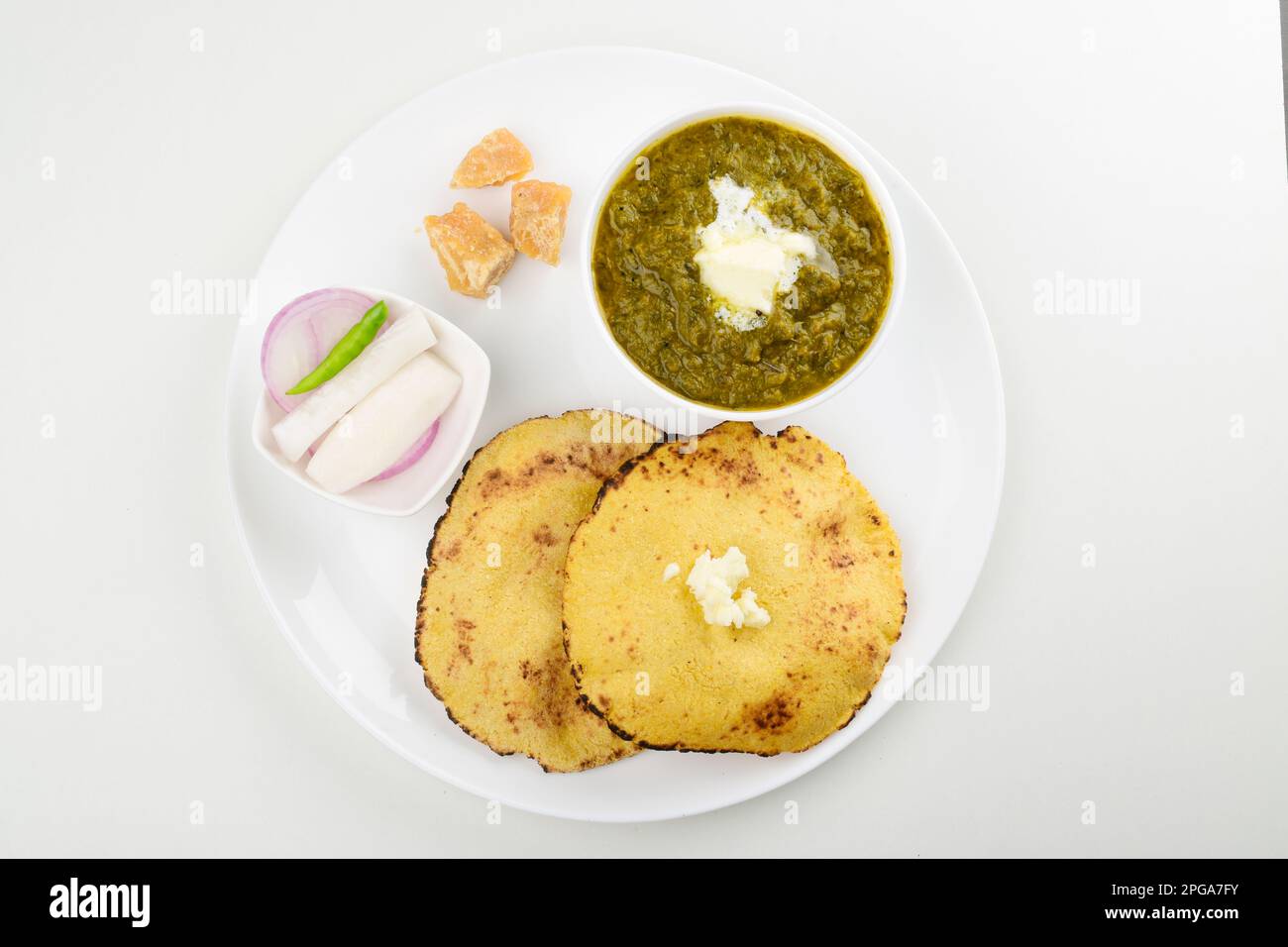 Vista dall'alto di saag e makki roti con burro bianco isolato su sfondo bianco Foto Stock