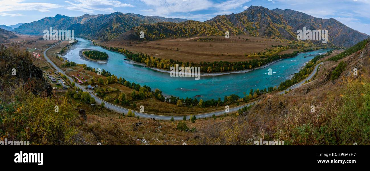 Panorama da una scogliera sopra il rapido fiume Katun sotto la montagna all'ombra e la strada vicino alle case vacanze in Altai in Siberia in autu Foto Stock