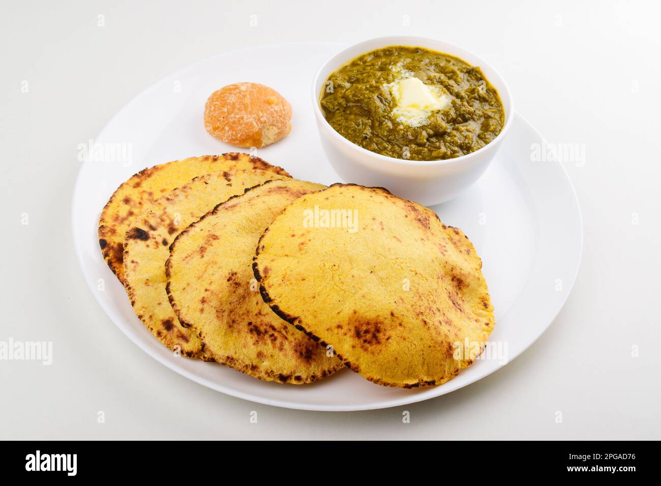 Makki roti con saag in piatto su sfondo bianco Foto Stock