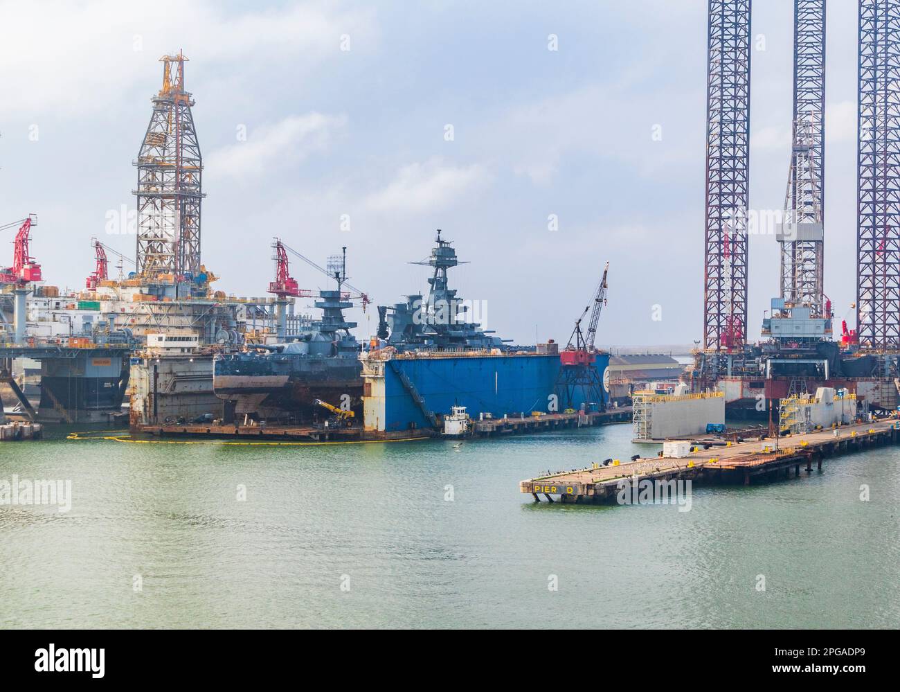 Vista dalla nave da crociera Ruby Princess mentre parte da Galveston. Nave da guerra USS Texas in riparazione presso le strutture di riparazione navale di Galveston Texas. Foto Stock