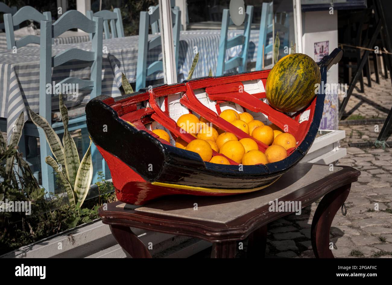 Arance e melone in mostra su un modello di barca da pesca portoghese Foto Stock