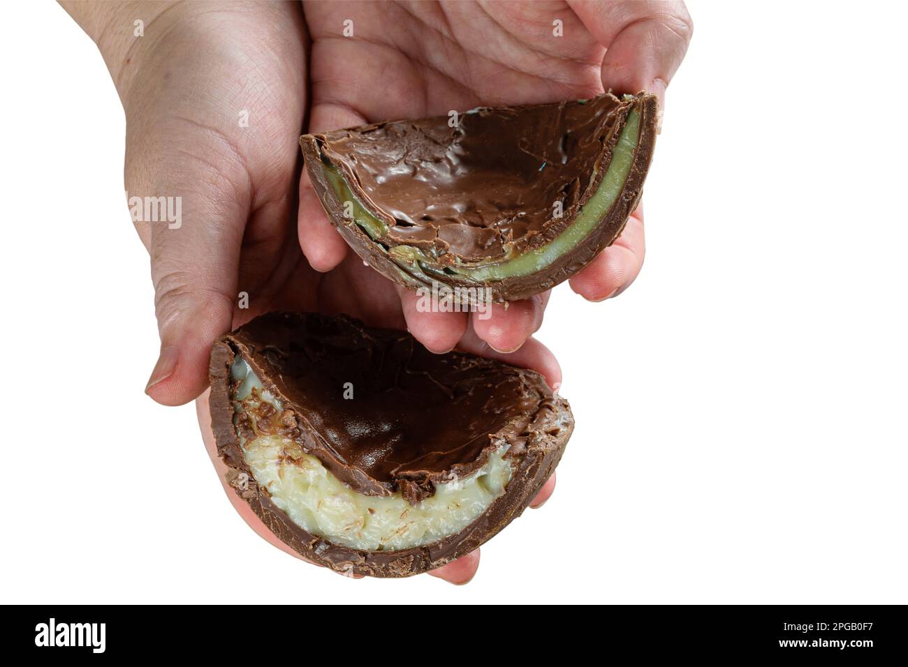 Pasticciere con due metà di uova di Pasqua al cioccolato farcite con brigadeiro bianco e brigadeiro con pistacchi. Foto Stock