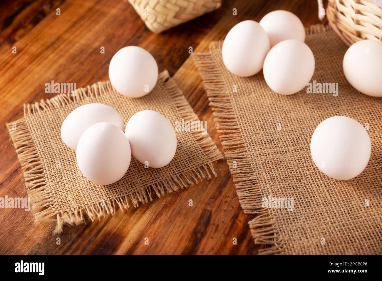 Molte uova bianche di pollo su un tavolo rustico di legno. Prodotto alimentare nutriente ed economico molto popolare. Foto Stock