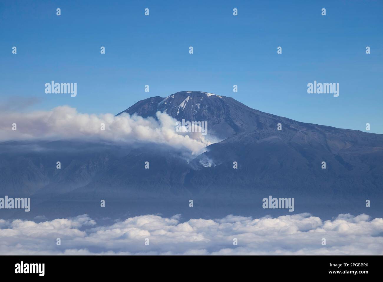 Veduta aerea, cima di montagna del vulcano Kilimanjaro con fuoco di foresta e fumo sul fianco della montagna, Tanzania, Africa orientale Foto Stock