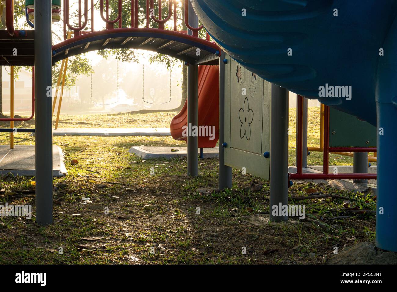 Parco giochi per bambini nel parco con luce del sole del mattino. Messa a fuoco selezionata sull'oscillazione. Foto Stock