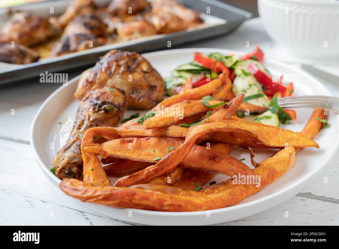 Patata dolce patatine fritte con pollo e insalata su un piatto Foto Stock