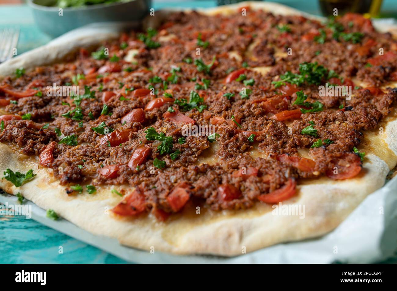 Pizza turca o lahmacun con carne macinata, pomodori, peperoni, cipolle, aglio, e prezzemolo, Foto Stock