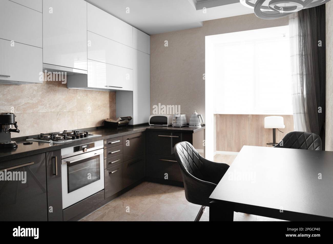 La cucina nell'appartamento. Il design della cucina. Interno grigio cucina con armadi bianchi. Forno da incasso all'interno della cucina. Foto Stock