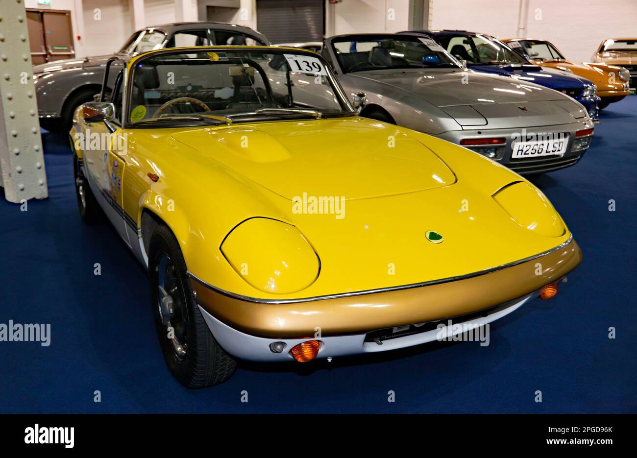 Vista frontale di tre quarti di un giallo e bianco, 1970, Lotus Elan S4/Sprint, parte della London Classic Car Auction 2023 ad Olympia, Londra Foto Stock