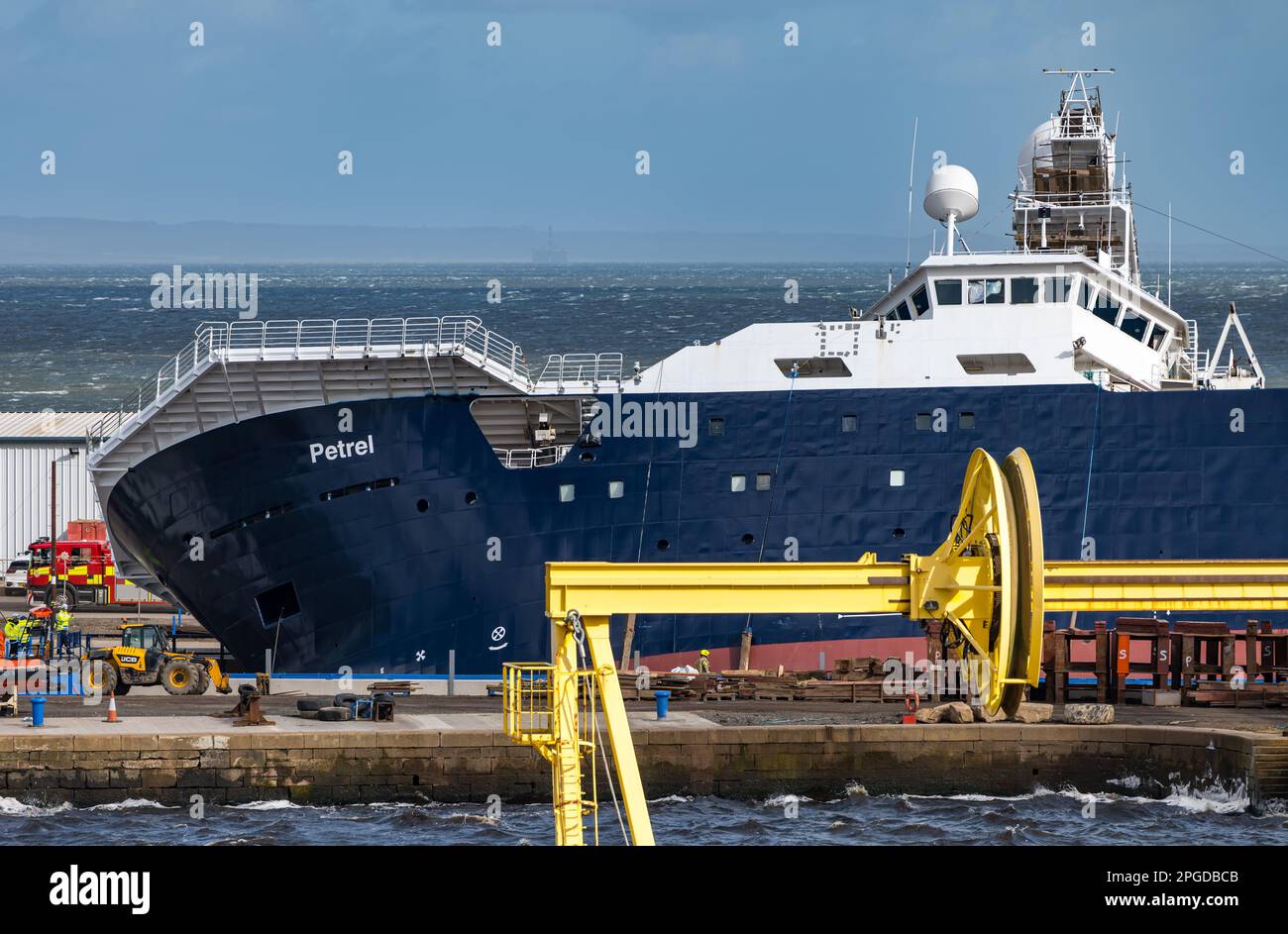 Leith Harbour, Edimburgo, Scozia, Regno Unito, 22nd marzo 2023. Elenco delle navi Petrel a 45 gradi: La Petrel, una nave da ricerca, è stata acquistata e attrezzata dal defunto co-fondatore di Microsoft Paul Allen. Forti venti hanno giocato un ruolo nel disalloggio mentre in Dales Marine dry dock. Sono presenti veicoli di emergenza. Credit: Sally Anderson/Alamy Live News Foto Stock