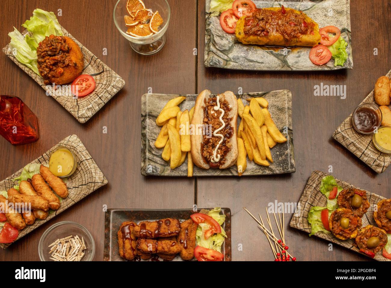 Set di ricette per cucina cubana, fast food e cucina venezuelana, un hot dog con salse, alcuni teques, un tamale, pollo in pastella e salse Foto Stock