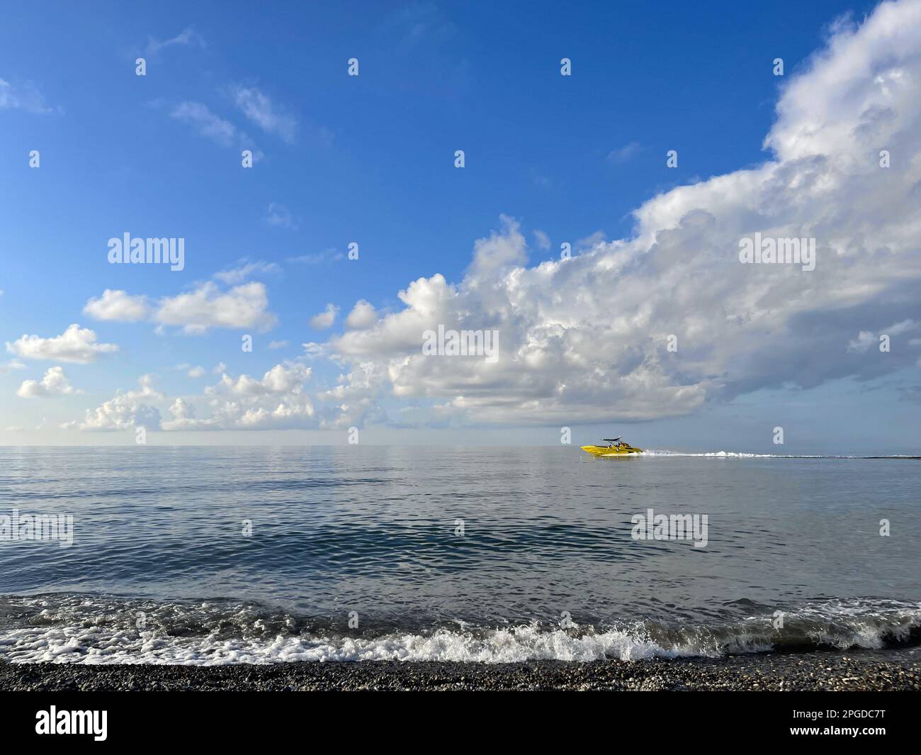 Mare onda in spiaggia, barca e cielo blu con nuvole bianche Foto Stock