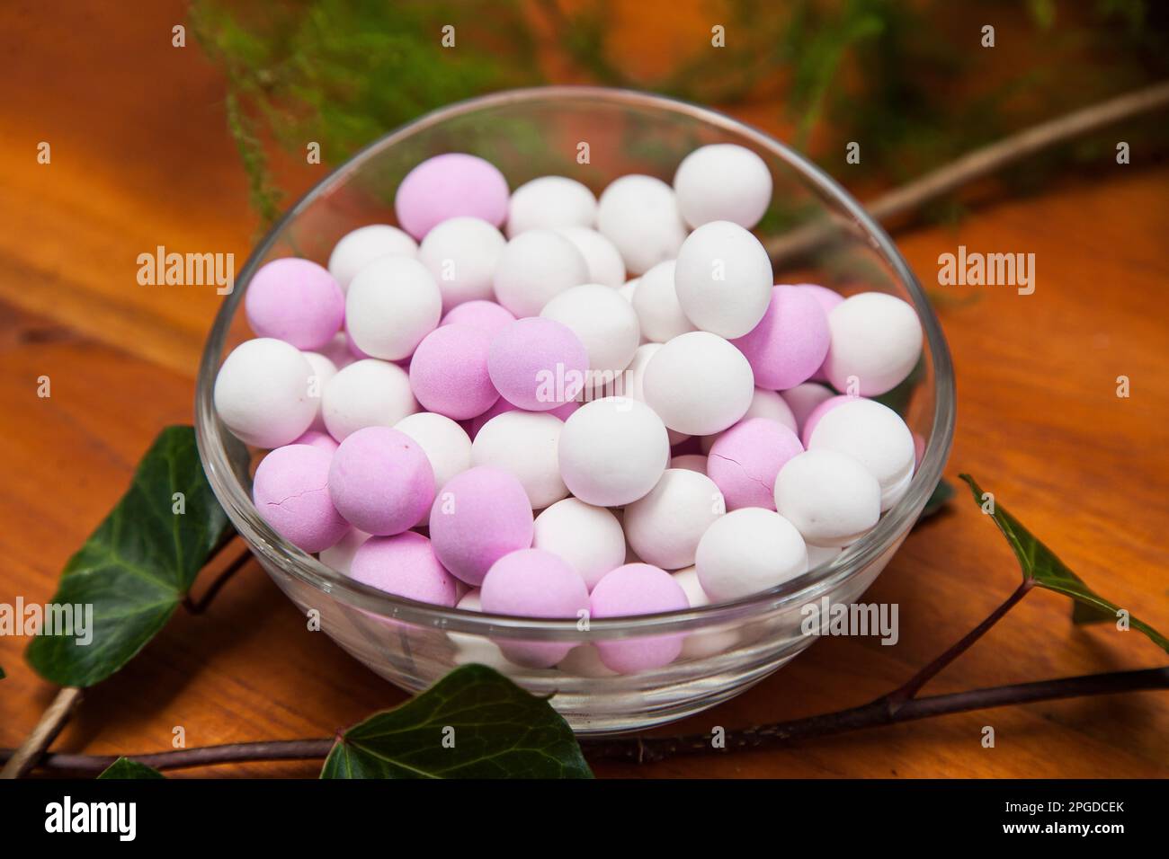 Ciotola di vetro con confetti bianchi e rosa. Foto Stock