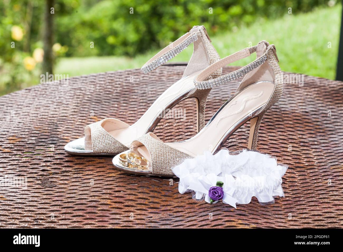 Matrimonio. Accessori sposa: lega, anelli di nozze vicino a scarpe da sposa su tacchi alti Foto Stock