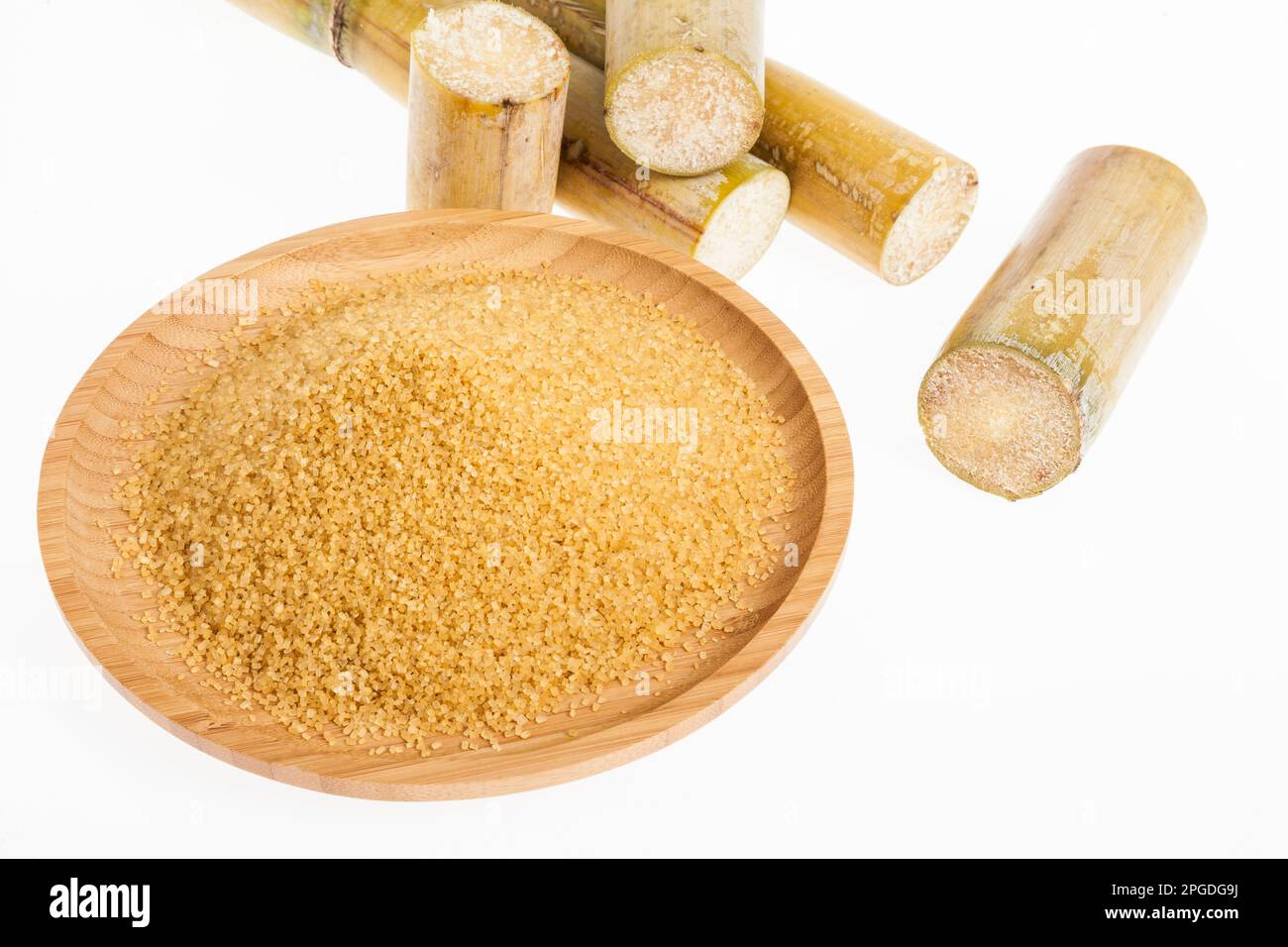 Piatto di legno con zucchero marrone su sfondo bianco Foto Stock