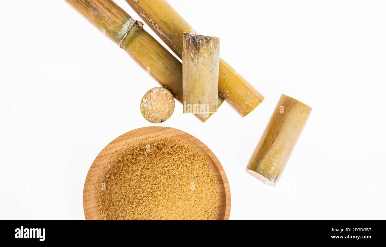 Piatto di legno con zucchero marrone su sfondo bianco Foto Stock