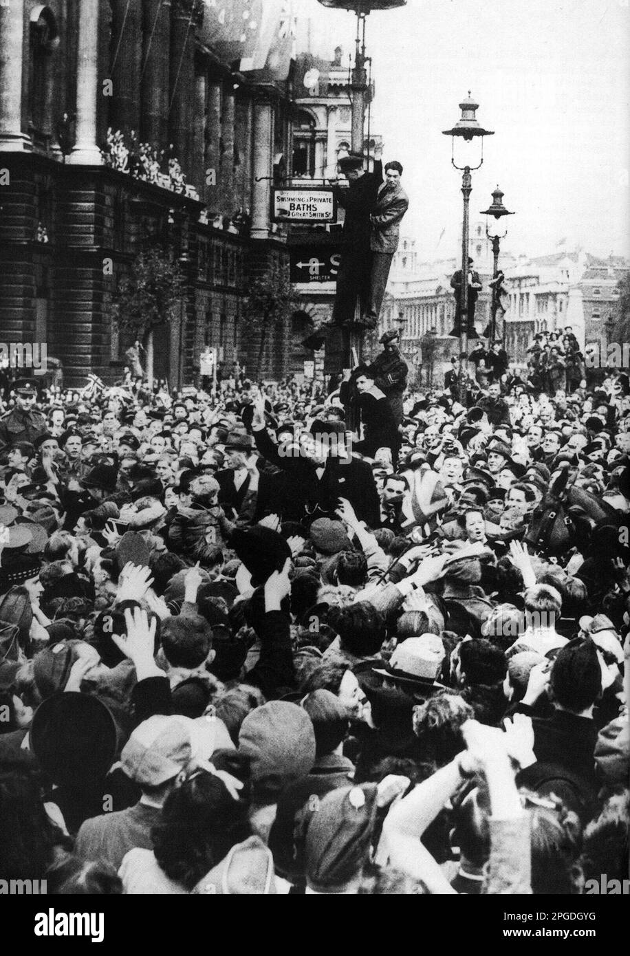 Winston Churchill circondato da folle che celebrano la vittoria. Londra 1945 Foto Stock