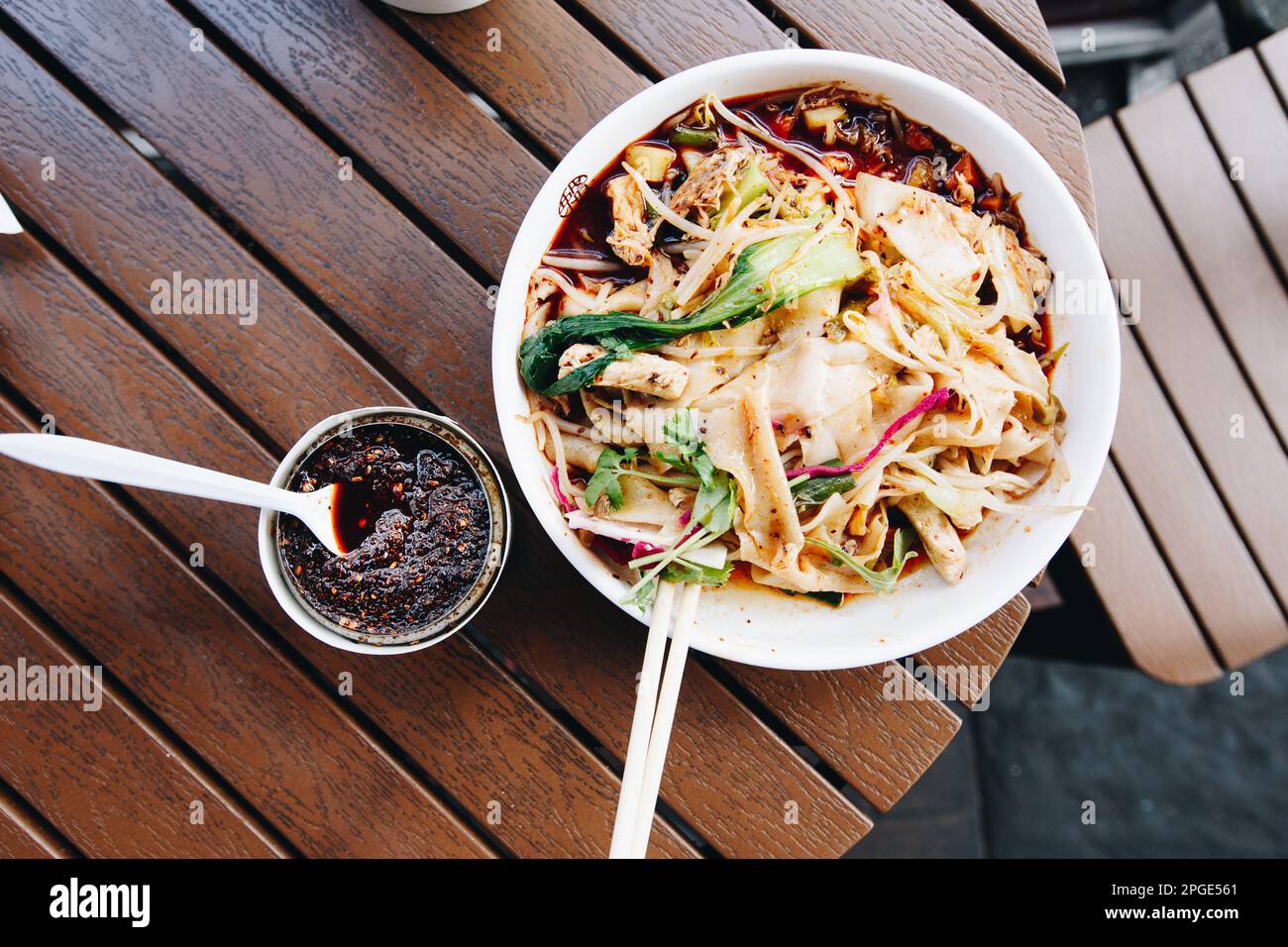 Il più famoso piatto cinese della provincia di Shaanxi chiamato spaghetti biang, in alternativa noto come youpo chemian, servito con pollo speziato con olio di giglio Foto Stock
