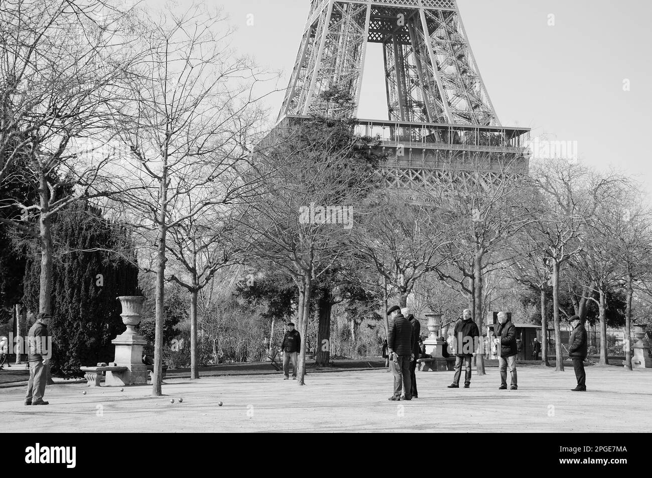 PARIGI, FRANCIA - 12 MARZO 2016: Un gruppo di uomini anziani che giocano a bocce nel parco ai piedi della torre Eiffel. Foto storica in bianco e nero Foto Stock