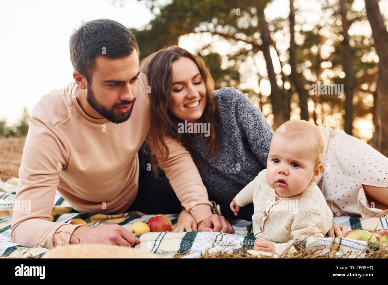 Haves pic-nic. La famiglia felice della madre, della famiglia e del bambino piccolo riposa all'aperto. Bella natura autunnale soleggiata Foto Stock