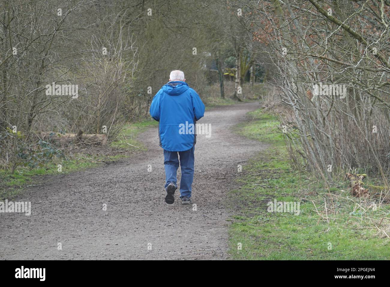 Un uomo anziano in cappotto blu cammina lungo il Sentiero della valle di Sett, Derbyshire Foto Stock