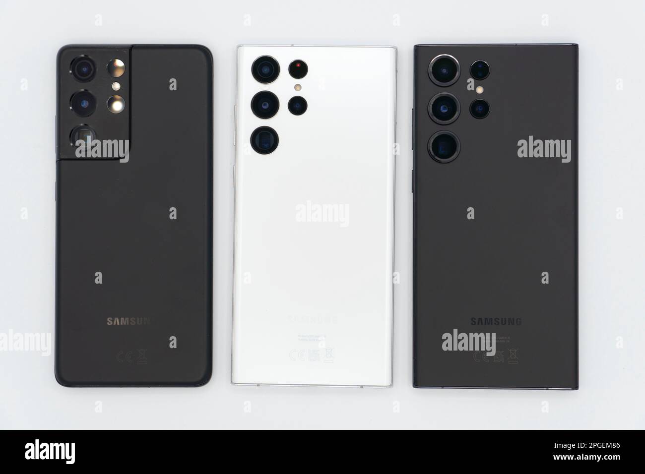 Vista ad angolo elevato di tre smartphone di punta Samsung Galaxy affiancati: Taglio S21 Ultra, S22 Ultra e S23 Ultra su sfondo bianco Foto Stock