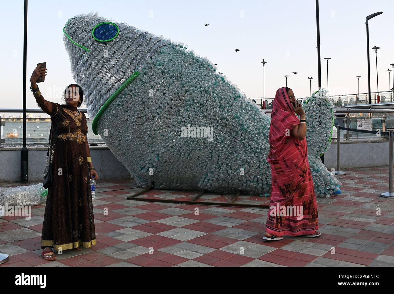 Mumbai, Maharashtra, India. 21st Mar, 2023. La gente è vista vicino all'installazione del pesce della bottiglia del PET (polietilentereftalato) a Mumbai. I giovani volontari di Change sono noi a creare il PET (polietilentereftalato) bottiglia pesce per creare consapevolezza circa il riciclaggio, più di seimila plastiche sono stati riutilizzati per creare questa gigantesca installazione. Secondo uno studio, entro il 2050 ci sarà più plastica che pesce nel mare e quindi è importante evidenziare il consumismo cosciente. (Credit Image: © Ashish Vaishnav/SOPA Images via ZUMA Press Wire) SOLO PER USO EDITORIALE! Non per USO commerciale! Foto Stock