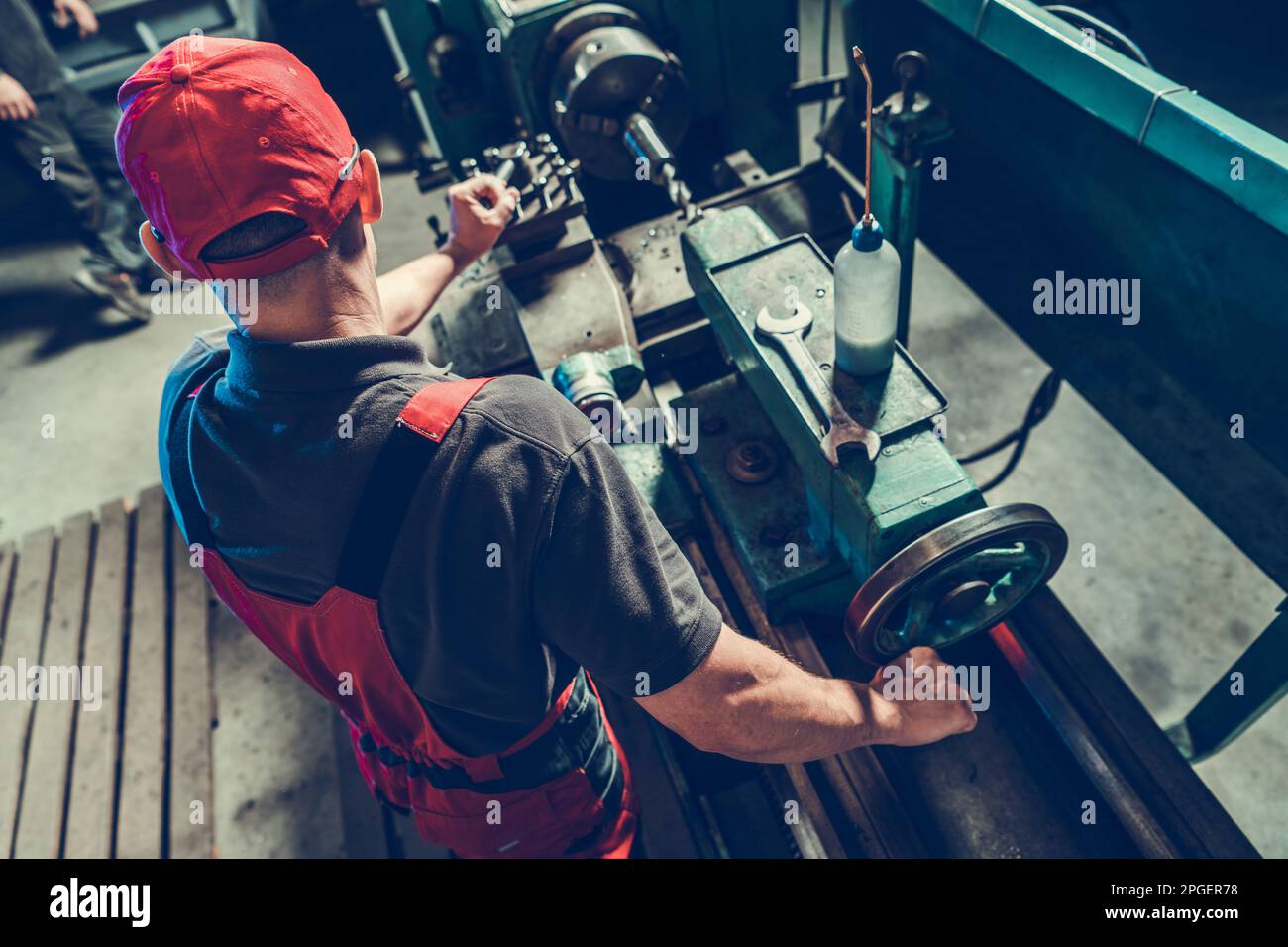 Lavoro operatore tornio per lavorazione metalli. Operatore macchina caucasica lavorazione pezzo di metallo. Foto Stock