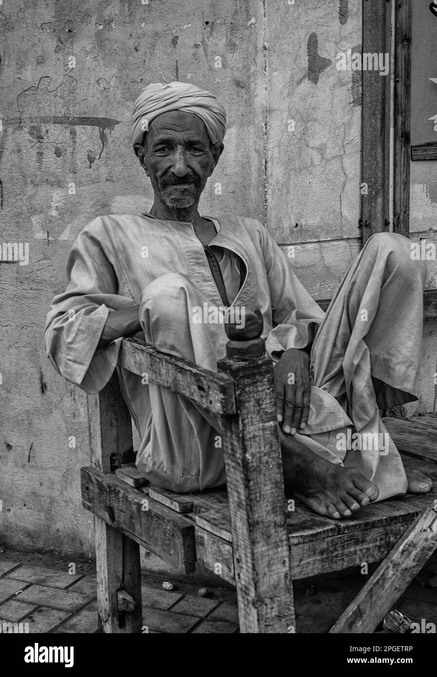 Ritratto di un egiziano seduto su una sedia. Luxor, Egitto. Foto Stock