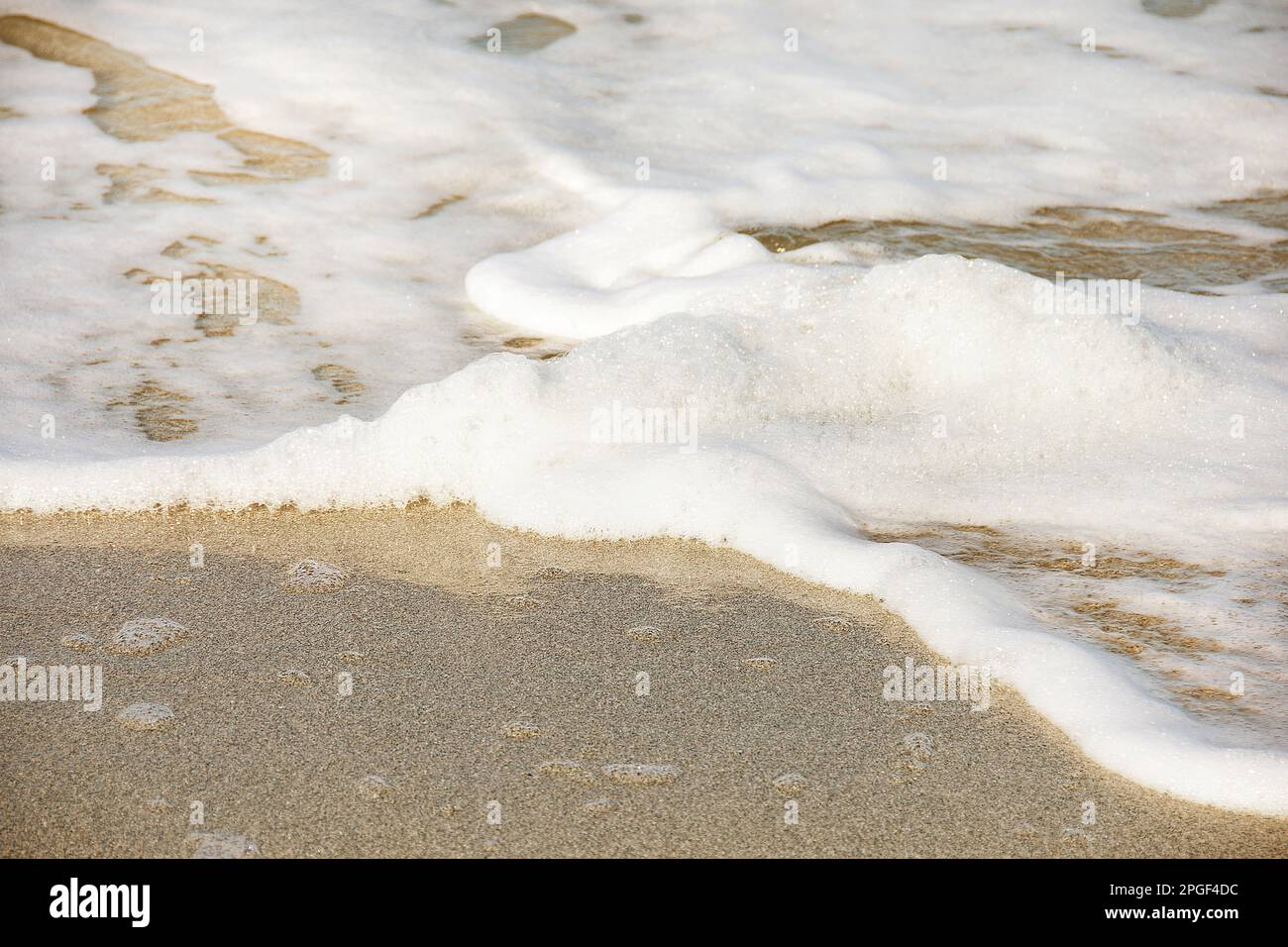 Schiuma bianca di mare di acqua salata sulla spiaggia tropicale Foto Stock