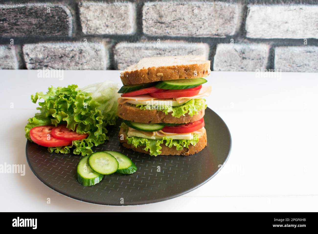 Delizioso panino con prosciutto, pomodoro, cetriolo, formaggio. Foto Stock