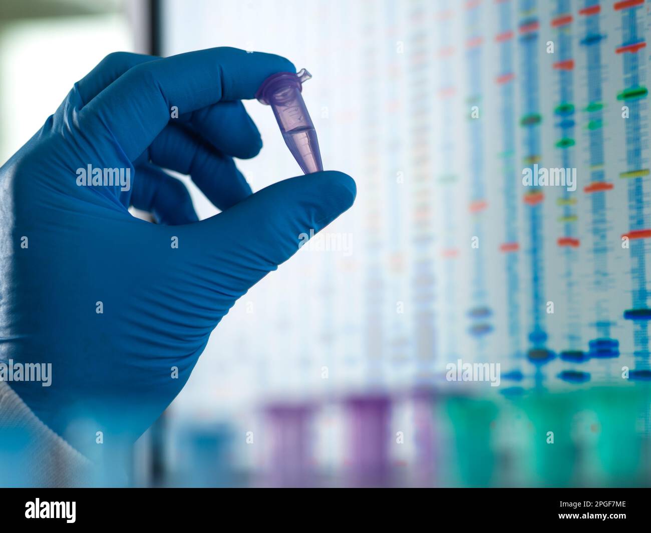 Scienziato che tiene una fiala contenente un campione di DNA pronto per l'analisi. Foto Stock