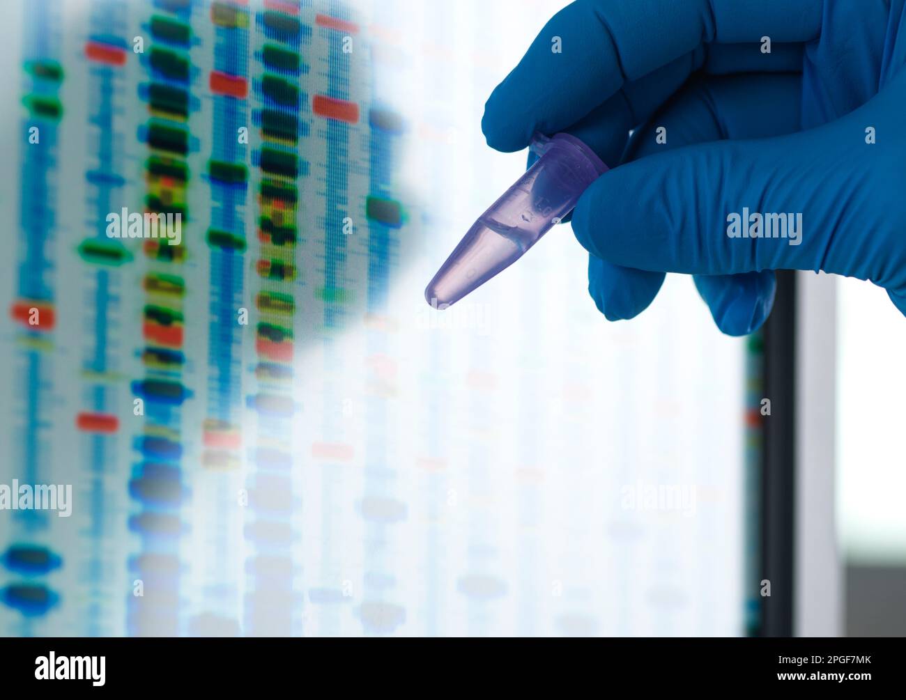 Scienziato che tiene una fiala contenente un campione di DNA pronto per l'analisi. Foto Stock