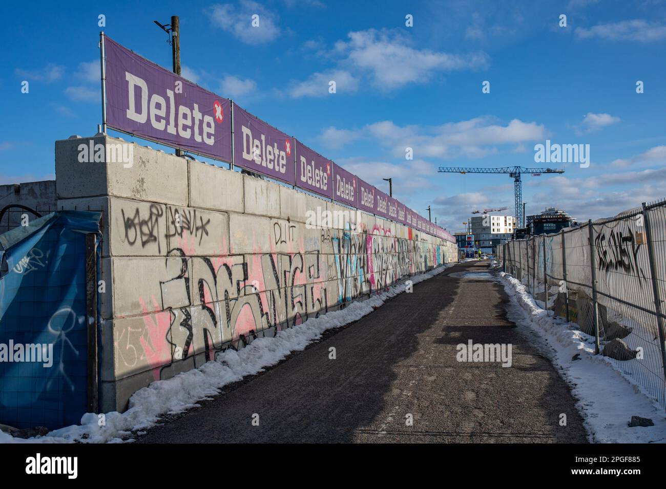 Muro di blocco di cemento che separa eliminare il sito di demolizione dal sentiero nel distretto di Kyläsaari di Helsinki, Finlandia Foto Stock