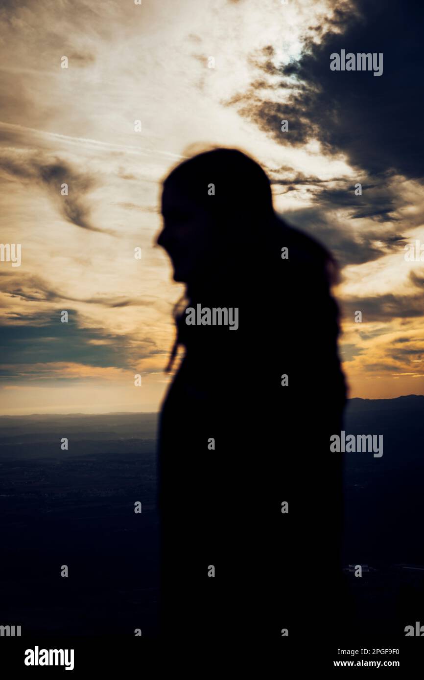 silhouette di una ragazza durante un bellissimo tramonto Foto Stock