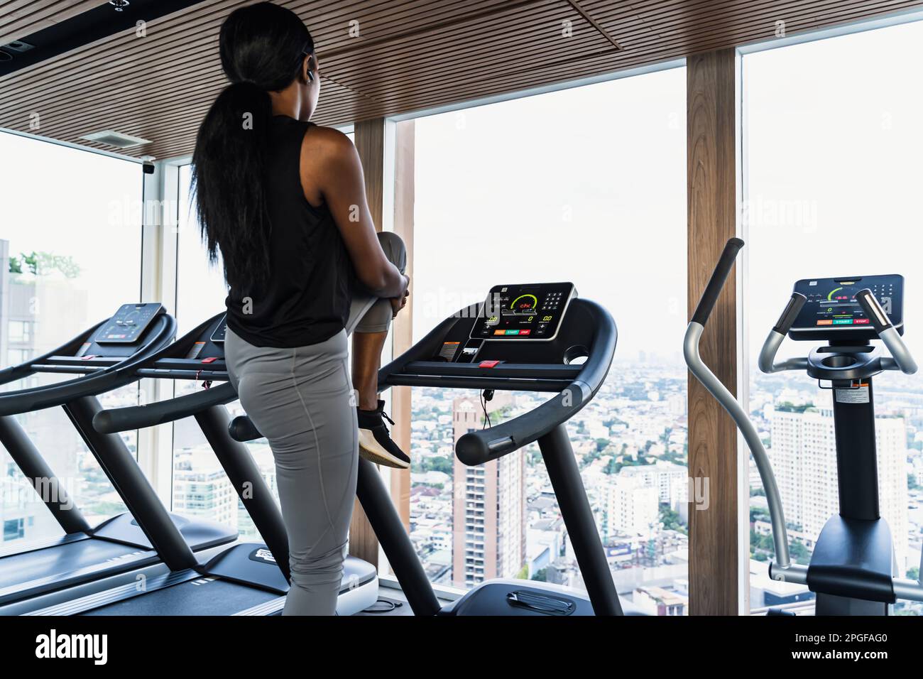donna africana in palestra stretching sul tapis roulant Foto Stock