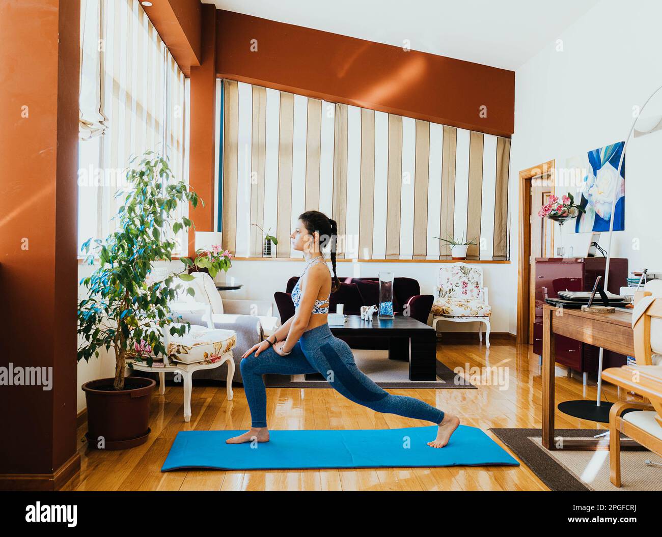 ritratto della donna che fa esercizi, yoga e stretching a casa Foto Stock