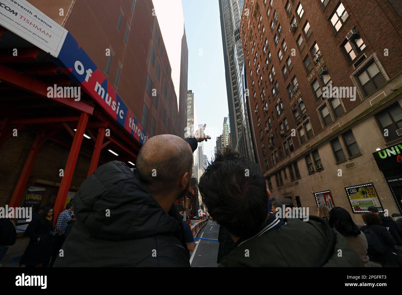 New York, Stati Uniti. 22nd Mar, 2023. I pedoni puntano ad un alto edificio sulla 56th Street ovest dove un uomo identificato come Ian Mitchel stava minacciando di saltare dopo che l'FBI servì un mandato di ricerca, New York, NY, 22 marzo 2023. Minacciando di saltare dal (stimato) 37th° piano di un alto edificio sulla West 56th Street, il team di risposta del NYPD ha chiuso la strada e configurato un airbag. (Foto di Anthony Behar/Sipa USA) Credit: Sipa USA/Alamy Live News Foto Stock