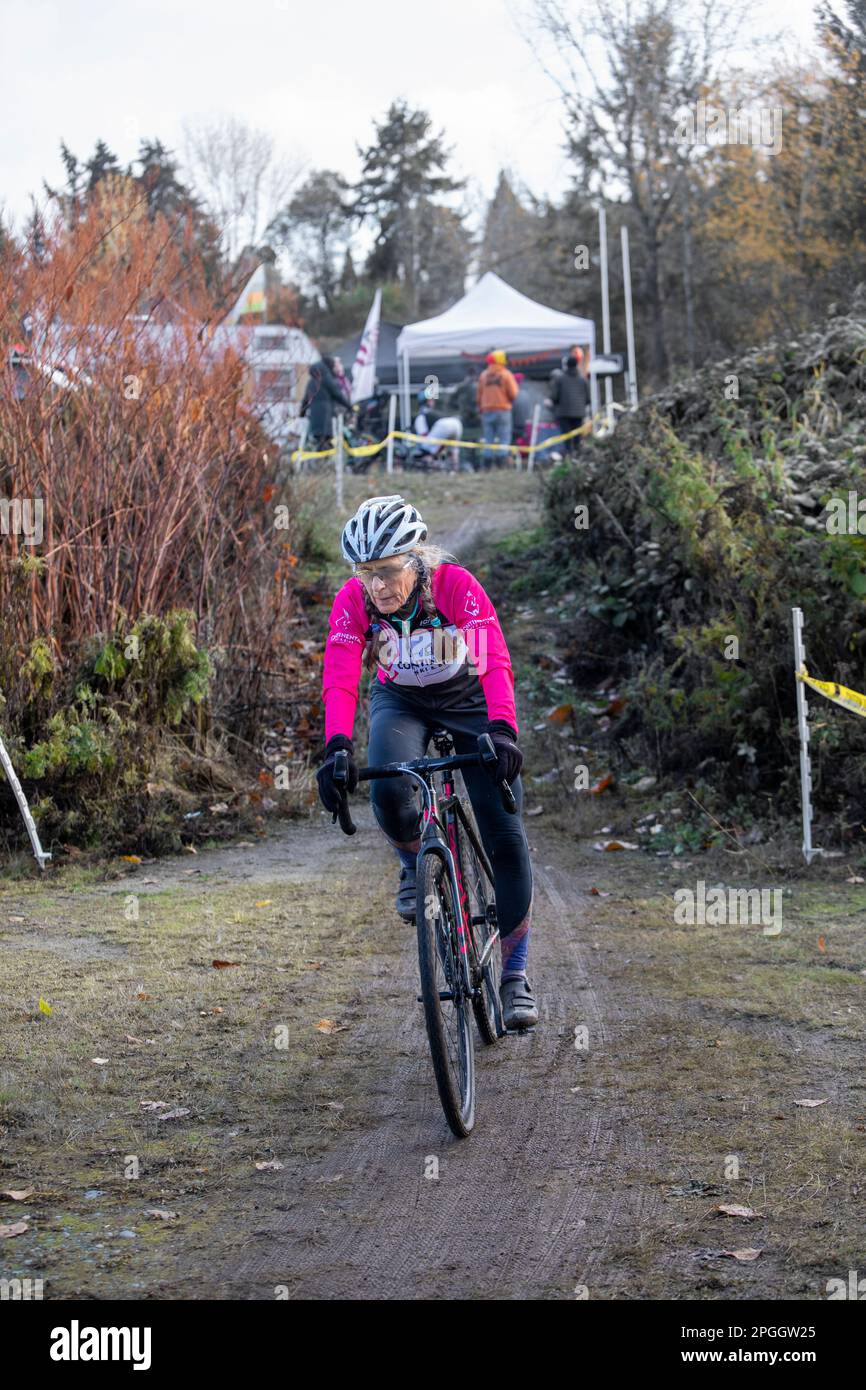 WA24119-00....Washington -ciclista senior Vicky Spring (69 anni), in competizione in una gara di ciclocross nella regione occidentale di Washington. Primavera Vicky in rosa. Foto Stock