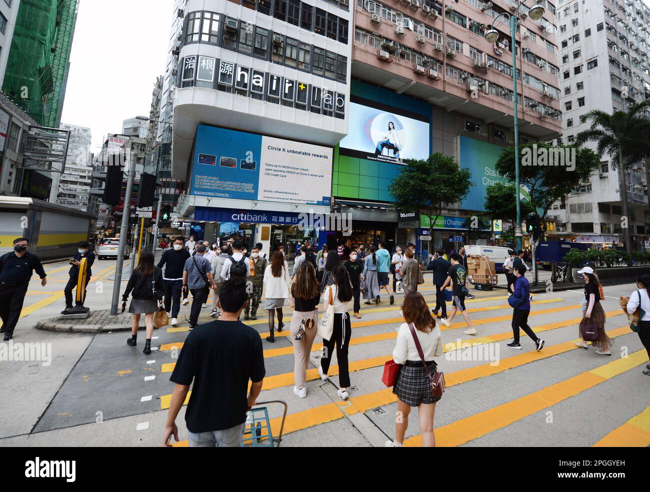 Pedoni che attraversano la strada a Mong Kok, Kowloon, Hong Kong. Foto Stock