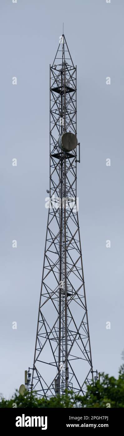 torre per telecomunicazioni alta con antenne per segnali dati cellulari montate su di essa. Tecnologia dati 5G Foto Stock