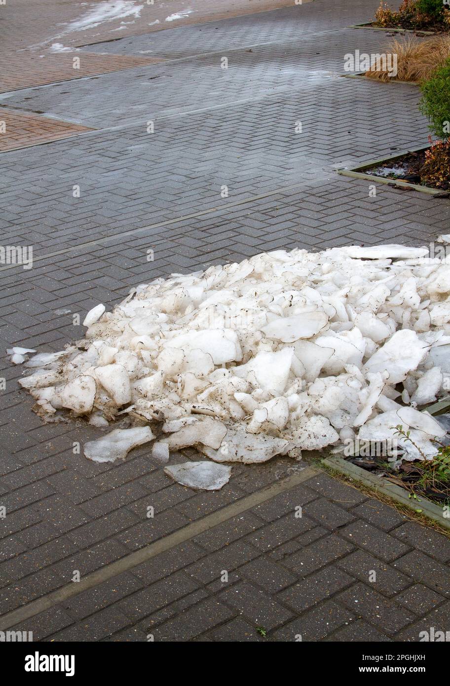 Un cumulo di neve e pezzi di ghiaccio in un angolo di un parcheggio Suffolk Foto Stock