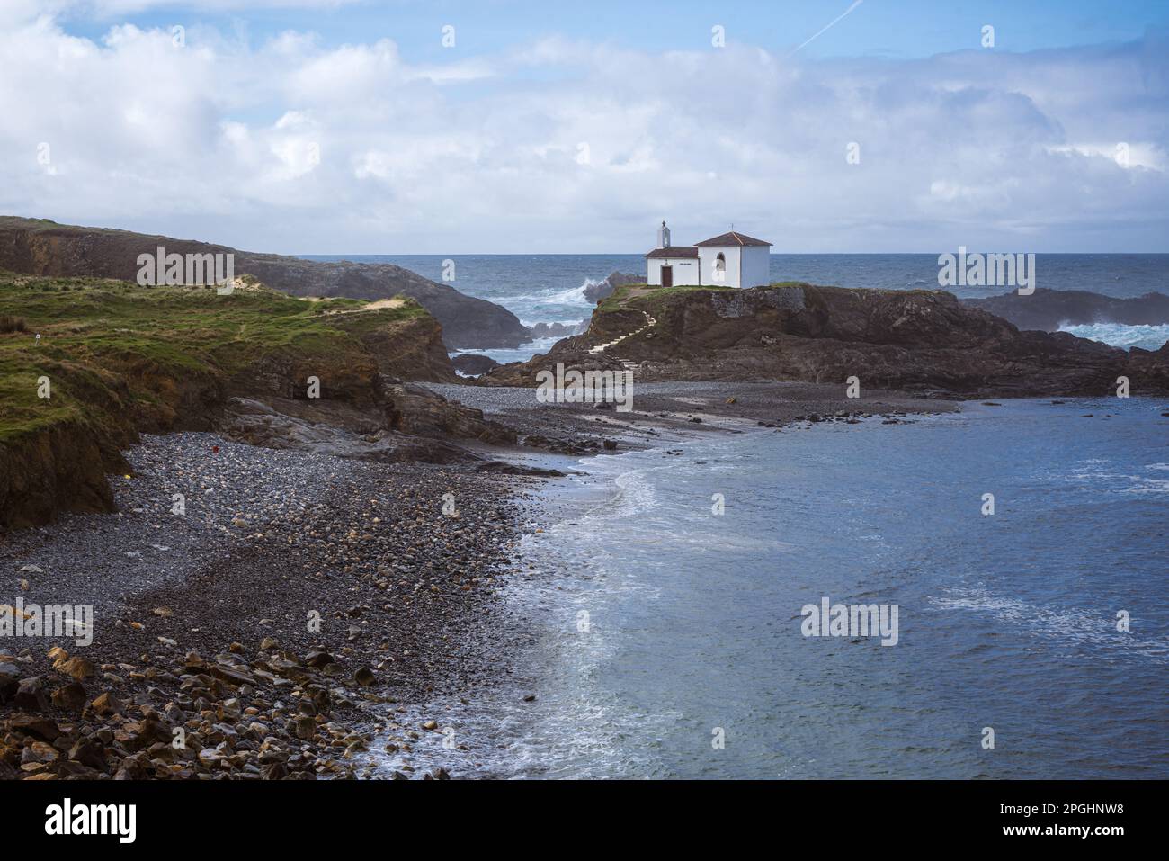 Costa dell'Oceano Atlantico. Galizia, Spagna. Vista panoramica di una cappella bianca sulla cima di una roccia e di una spiaggia di pietra ondulata. A Virxe do Porto Ermitage Foto Stock