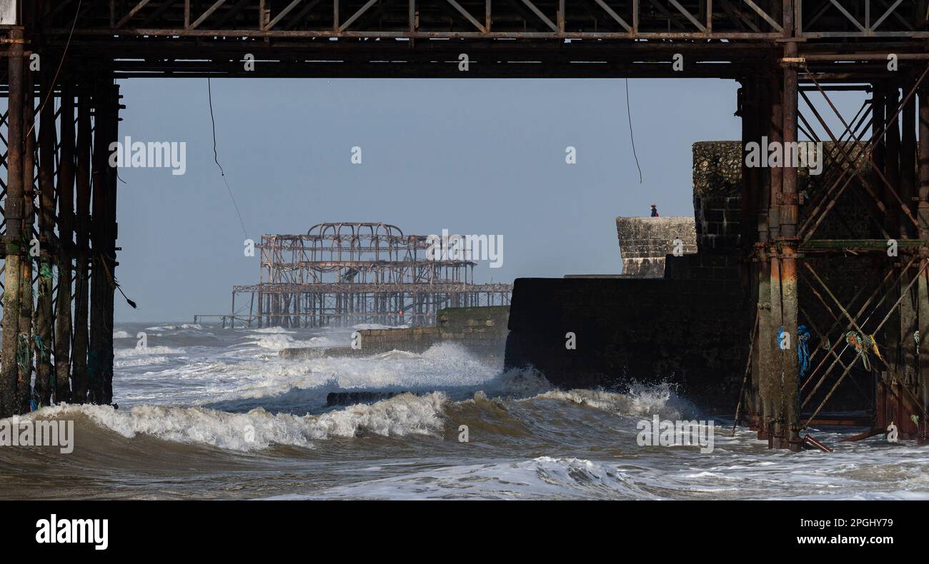 Brighton UK 23rd marzo 2023 - le onde si schiantano sul lungomare di Brighton in una giornata soleggiata ma ventosa lungo la costa meridionale : Credit Simon Dack / Alamy Live News Foto Stock