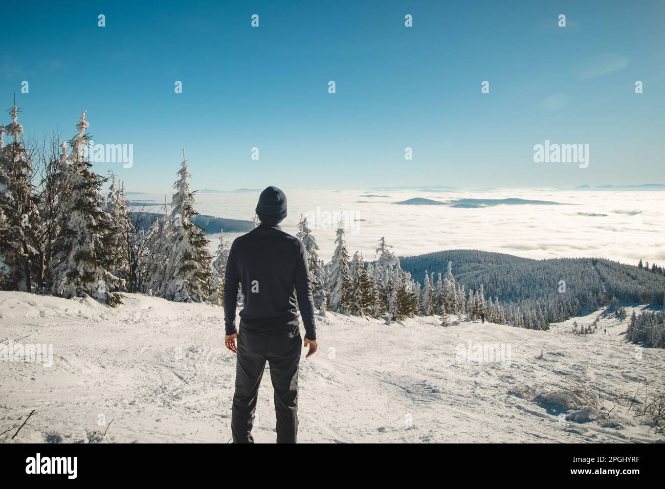 Il giovane viaggiatore entusiasta gode della vista dalla montagna più alta delle montagne Beskydy nell'Europa centrale del paesaggio innevato che scompare Foto Stock