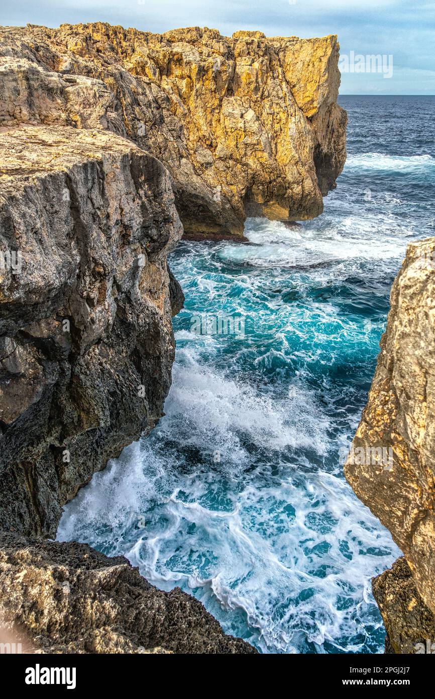 Le scogliere sulle quali si infrangono le onde tempestose del mare lungo la costa della Riserva Naturale del Plemmirio. Siracusa, Sicilia, Italia, Europa Foto Stock