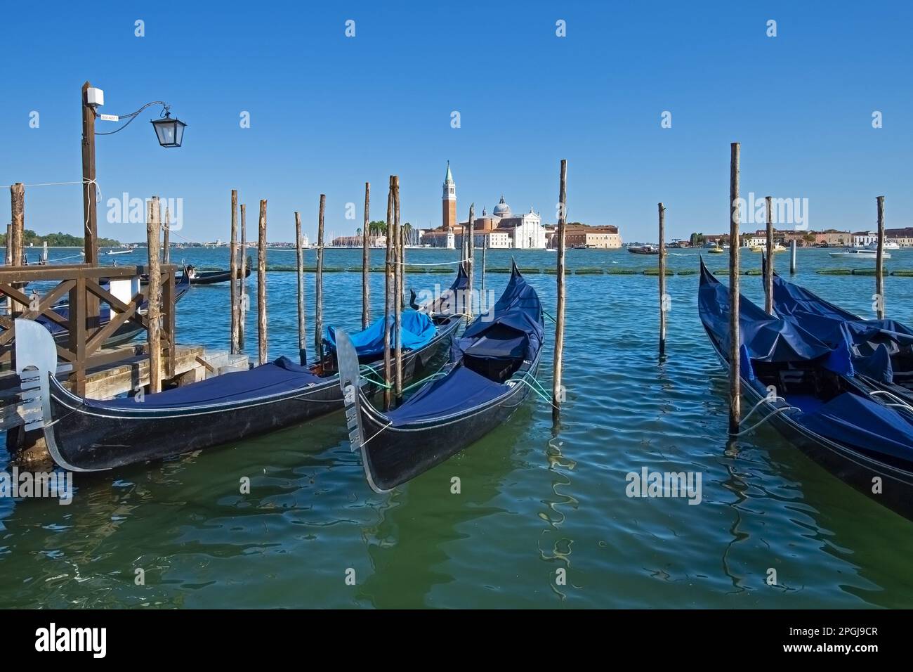 Gondole sul lungomare con l'Isola di San Giorgio, Piazza San Marco con il Campanile sullo sfondo, Italia, Venezia Foto Stock