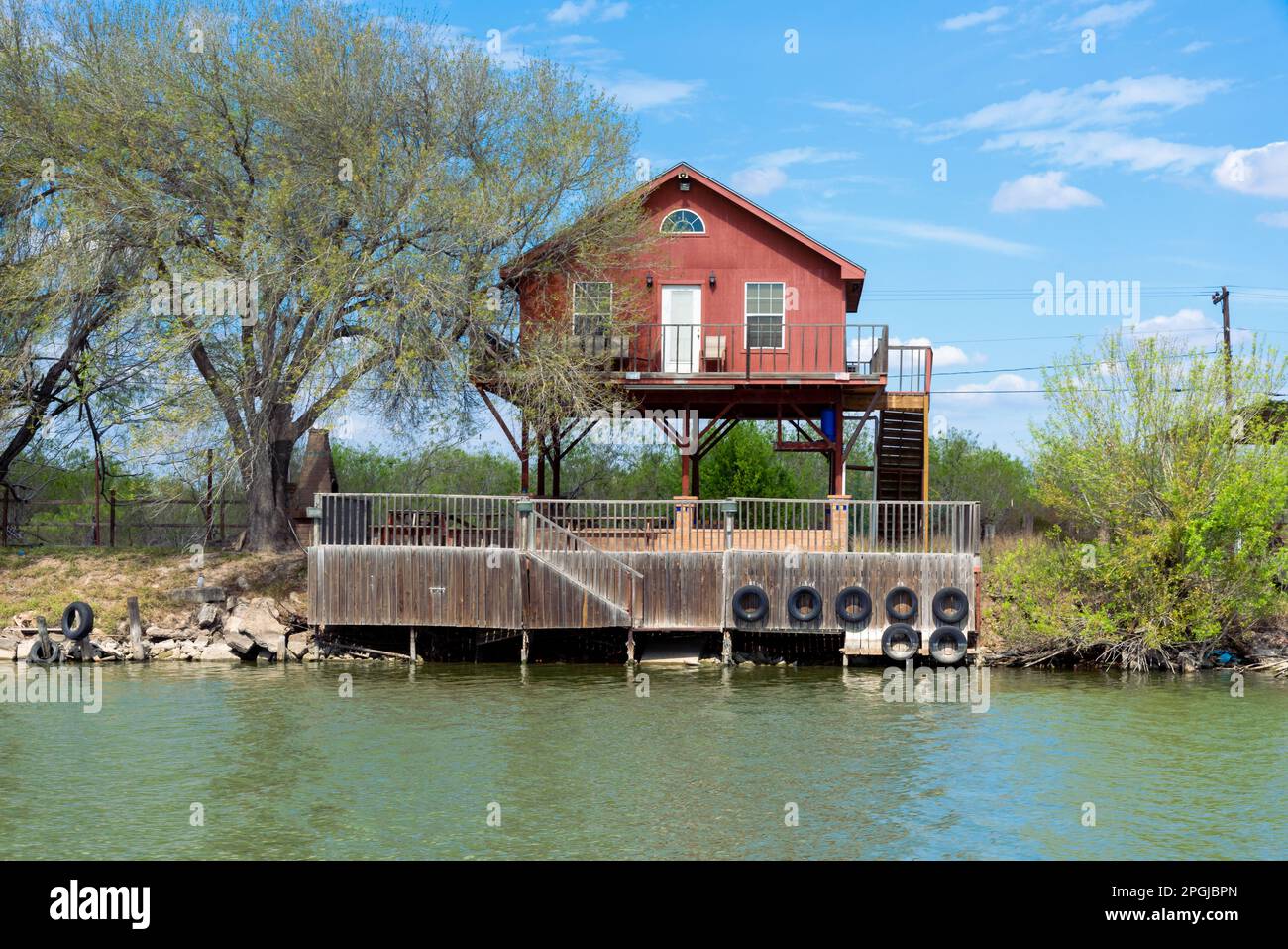 Una piccola casa su palafitte sulla riva del fiume Rio Grande a Mission, Texas. Foto Stock