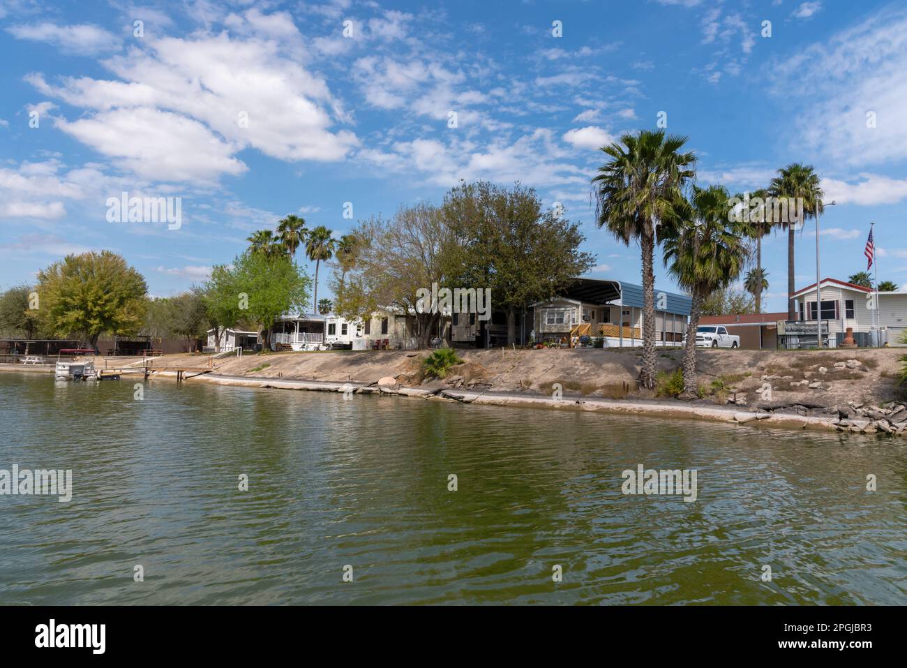 Chimney Park RV Resort sul fiume Rio Grande a Mission, Texas, sul confine con gli Stati Uniti messicani, guardando attraverso il fiume su terra. Foto Stock
