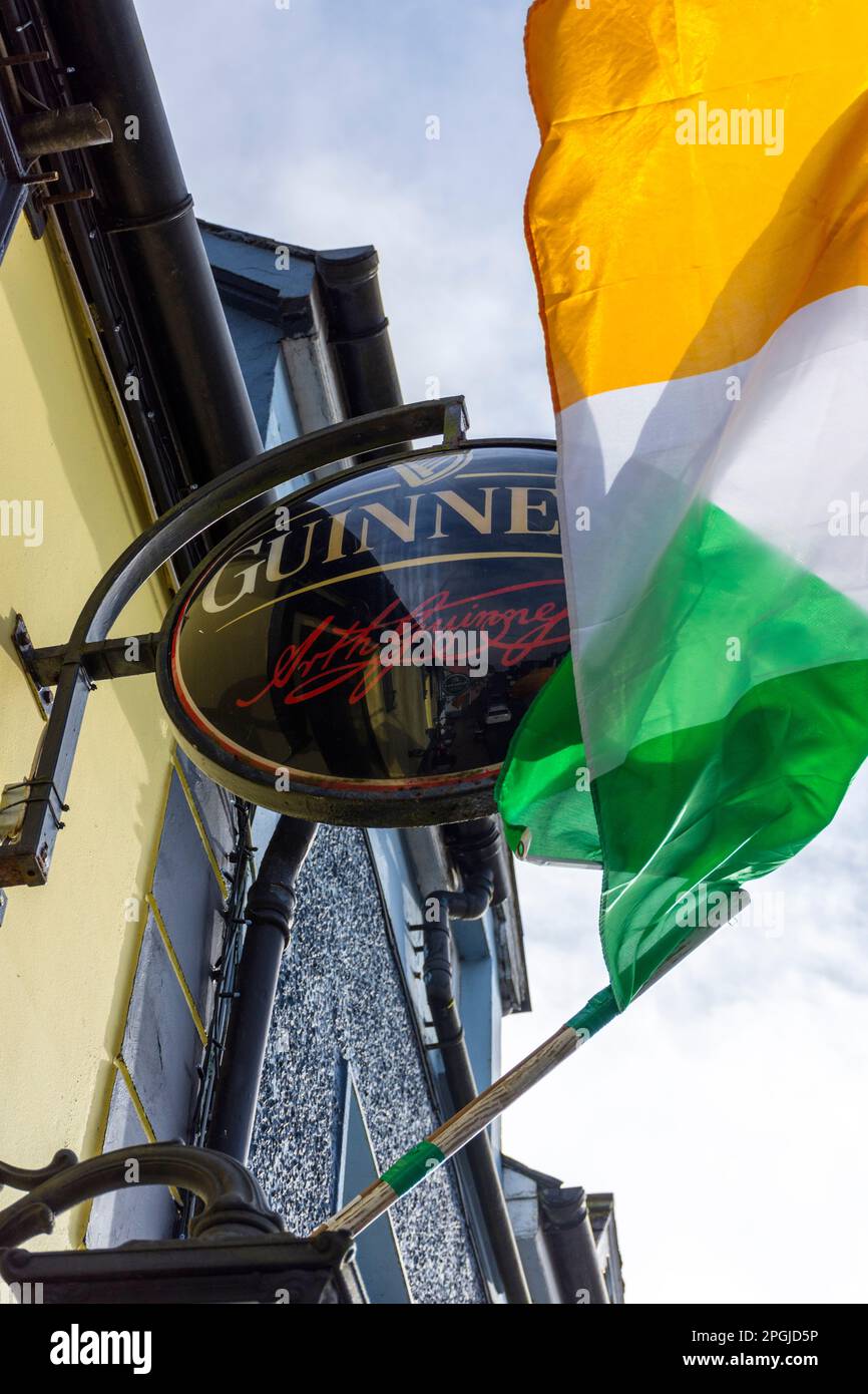 Bandiera nazionale tricolore irlandese e cartello Guinness fuori da un bar nella Contea di Donegal, Irlanda Foto Stock